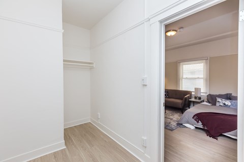 A bedroom with a bed and a couch in the background.