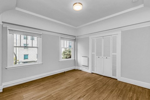 A room with a window and a door is empty and waiting to be furnished.