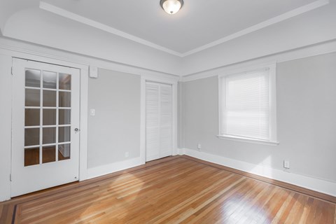 A room with a white door and a window with blinds.