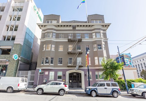 A building with a green sign on the front and a flag on top.