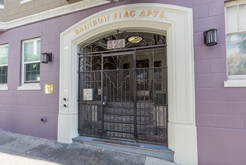 The entrance to a building with a sign that says "Rainbow Flag Apts.".