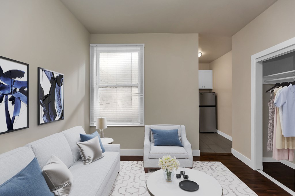 A living room with a white couch and blue pillows.