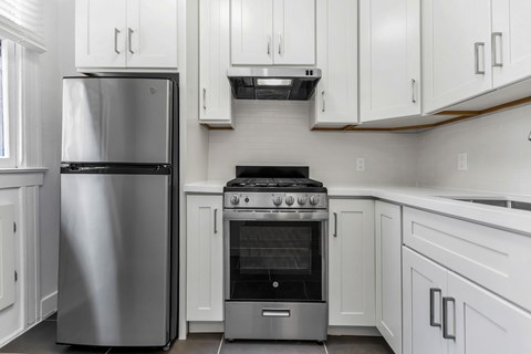 A modern kitchen with a stainless steel refrigerator and oven.