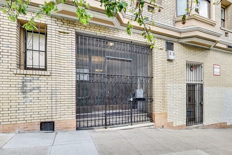 A black metal gate is on a brick wall.