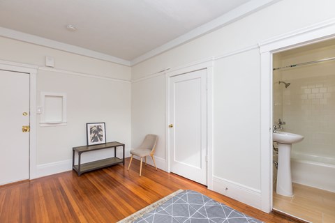 A bathroom with a white sink and a wooden floor.