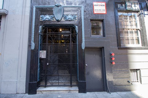 A building with a black door and a sign that says "Rent Now".