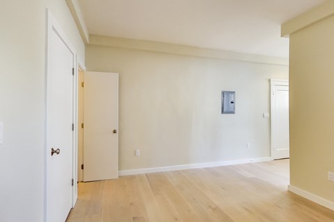 A room with a white door and a wooden floor.