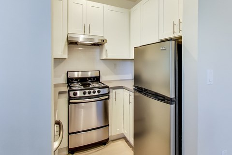 A kitchen with a stainless steel refrigerator and stove.
