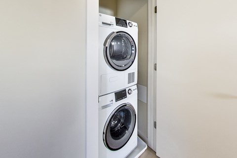 A white front loading washing machine in a laundry room.