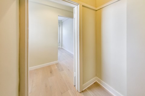 A room with a white door and wooden floor.