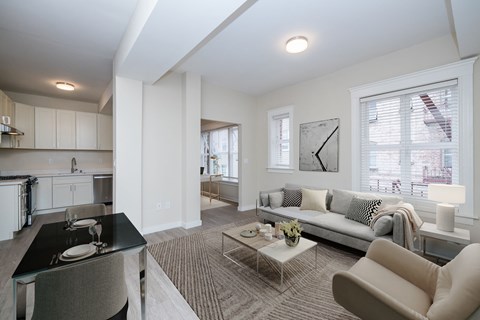 A modern living room with a grey sofa and a glass table.