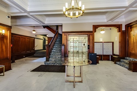 A large, elegant room with a staircase and a chandelier.
