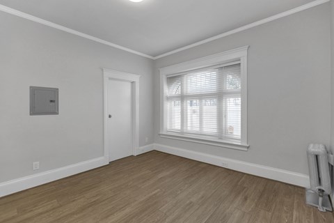 A room with a window and a radiator on the floor.