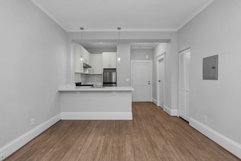 A kitchen with white cabinets and a wooden floor.