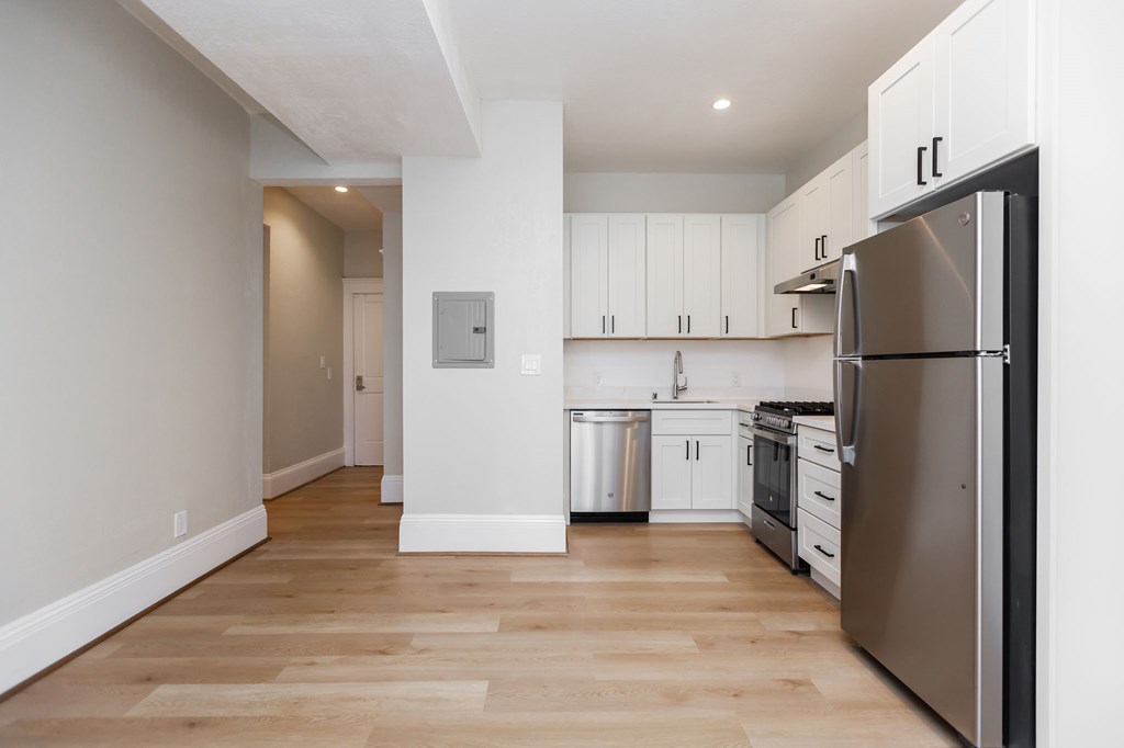 a renovated kitchen with stainless steel appliances and white cabinets