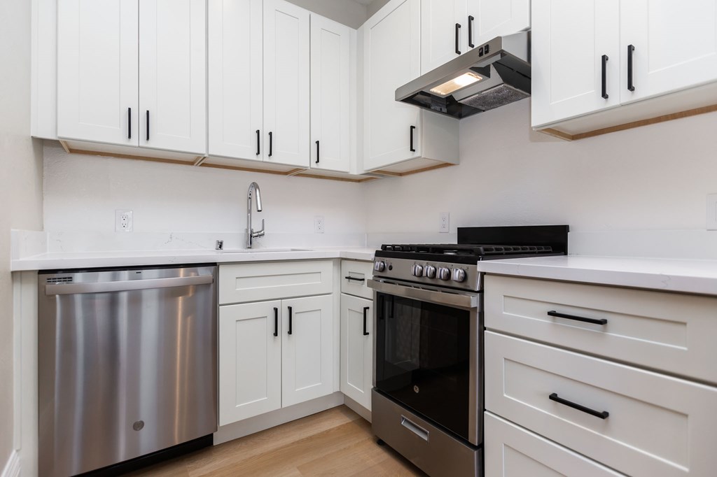 a kitchen with white cabinets and stainless steel appliances