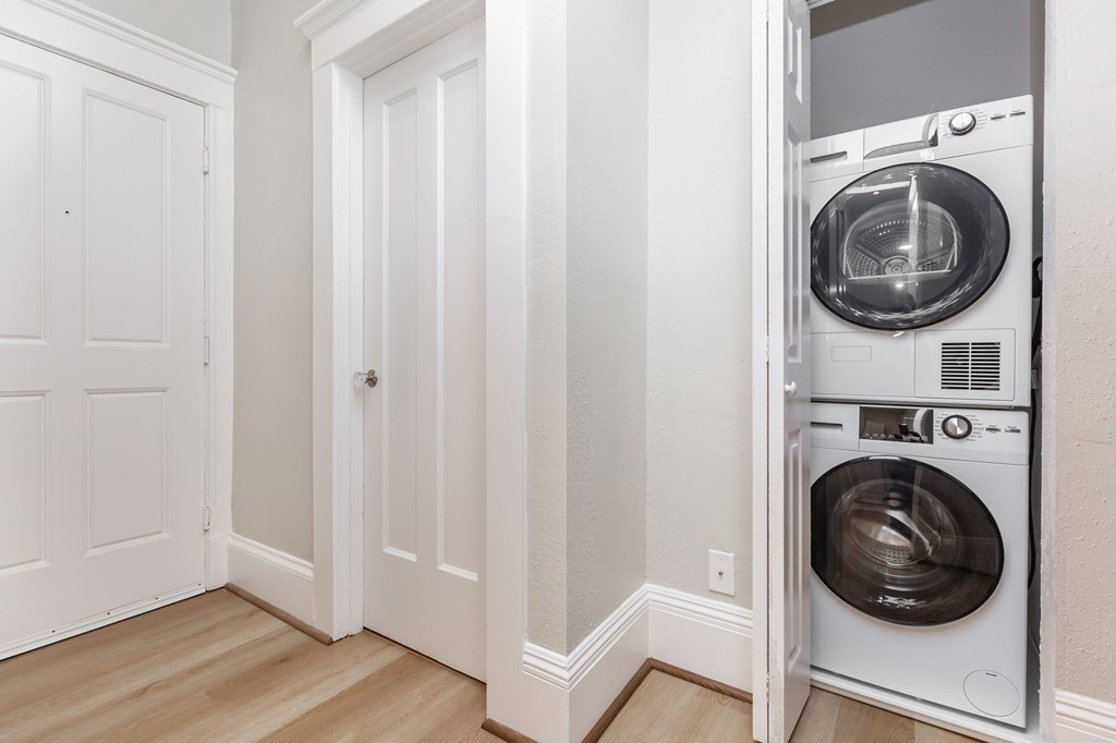 a washer and dryer in a closet in a room with a door
