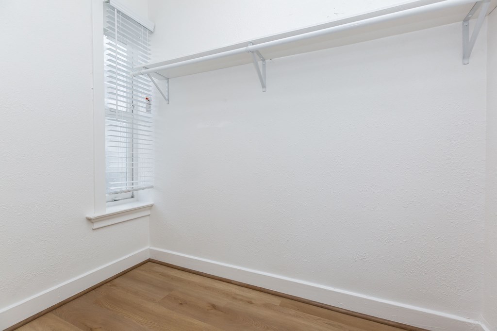 a room with white walls and a window and a wooden floor