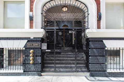 A black wrought iron gate with the name "Rex Arms" on it.