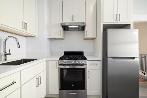 A modern kitchen with white cabinets and stainless steel appliances.