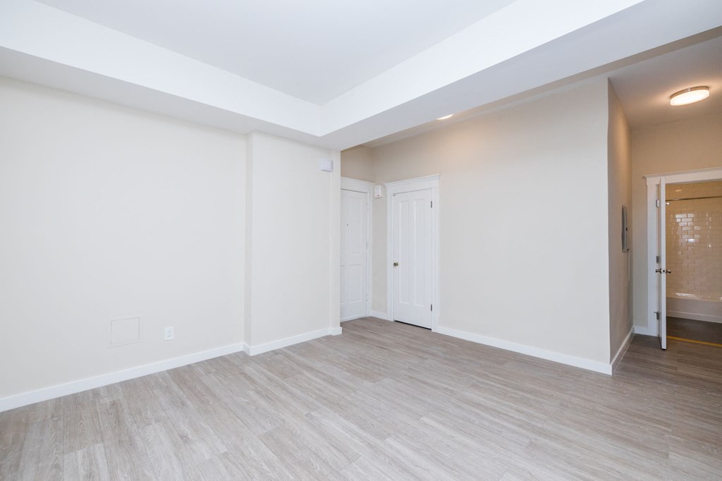 an empty living room with white walls and wood flooring