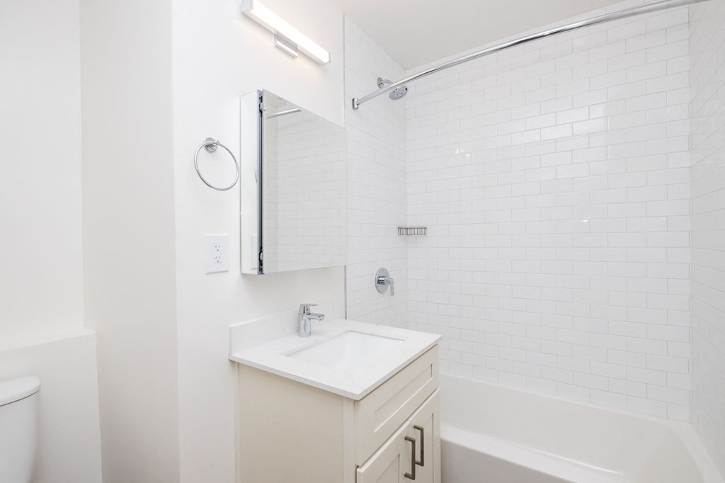 a white bathroom with a sink and a tub