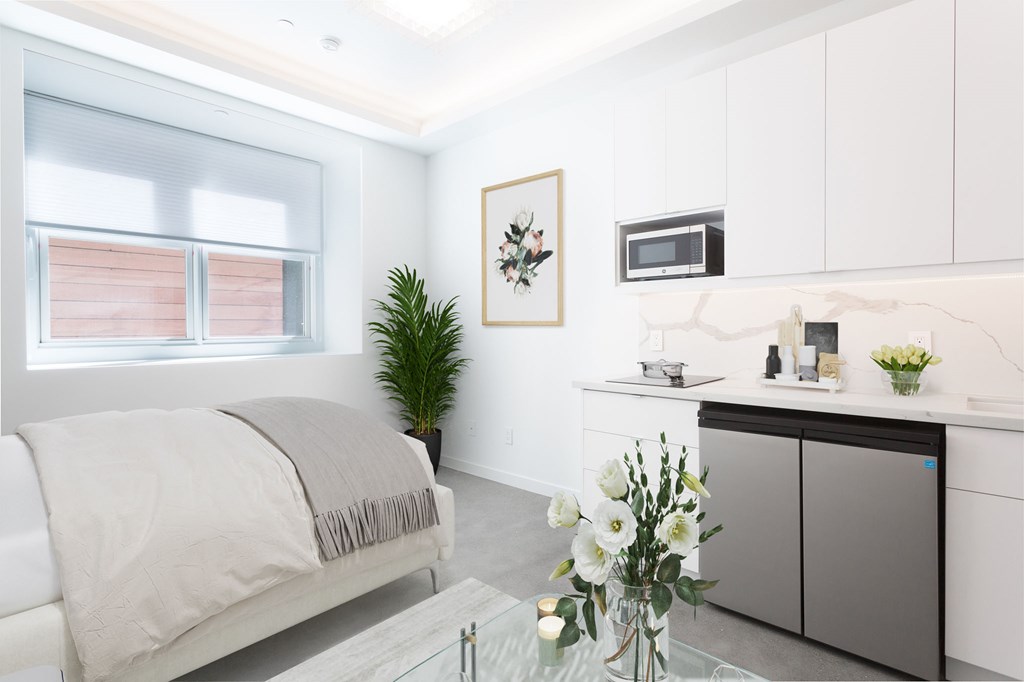 a white bedroom with a bed and a table with flowers