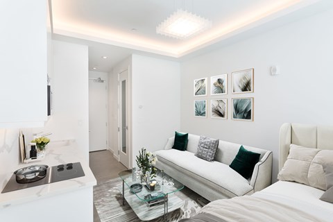 A modern living room with a white couch and a glass coffee table.