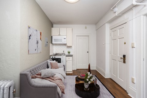 A living room with a grey couch and a coffee table with flowers on it.