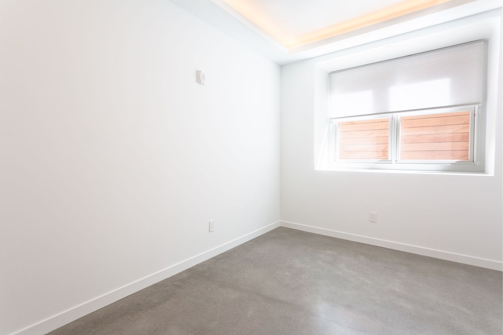 an empty room with white walls and a window