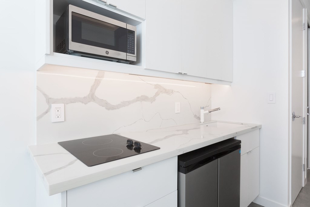 a white kitchen with a microwave and a stove