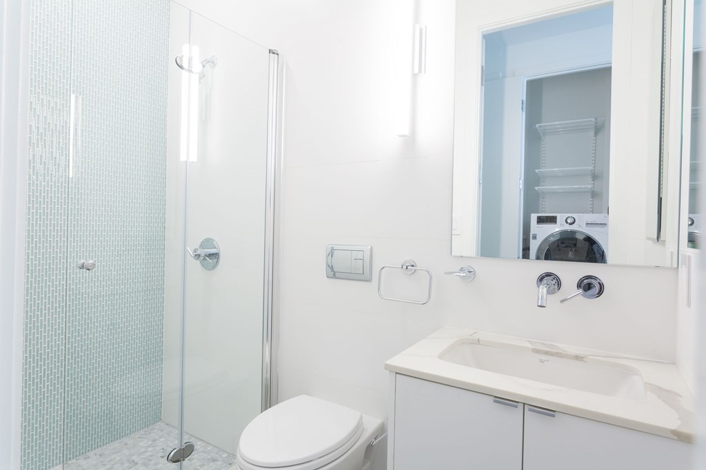 a white bathroom with a shower sink and toilet
