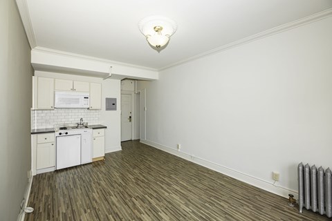 A small kitchen with white cabinets and a white fridge.
