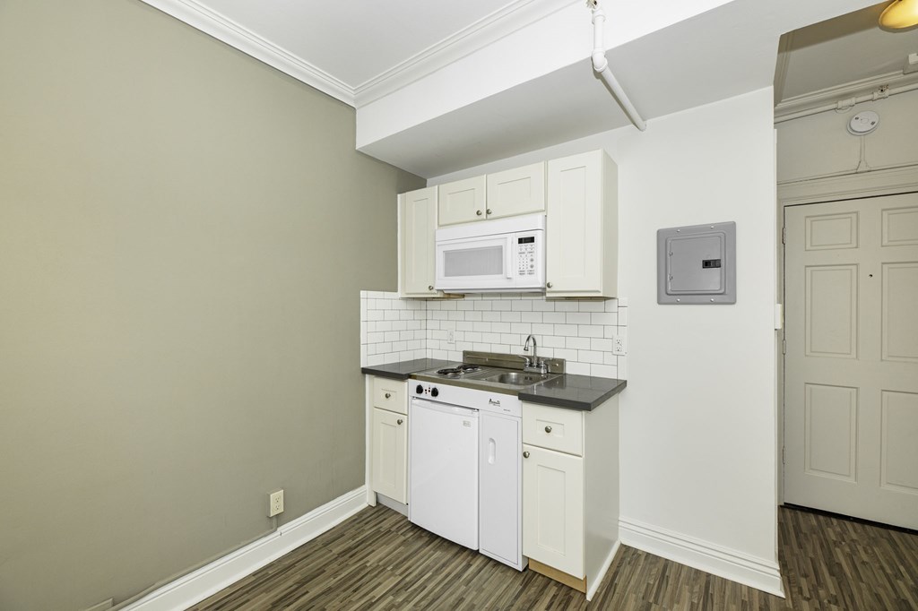 a kitchen with white cabinets and a sink and a microwave