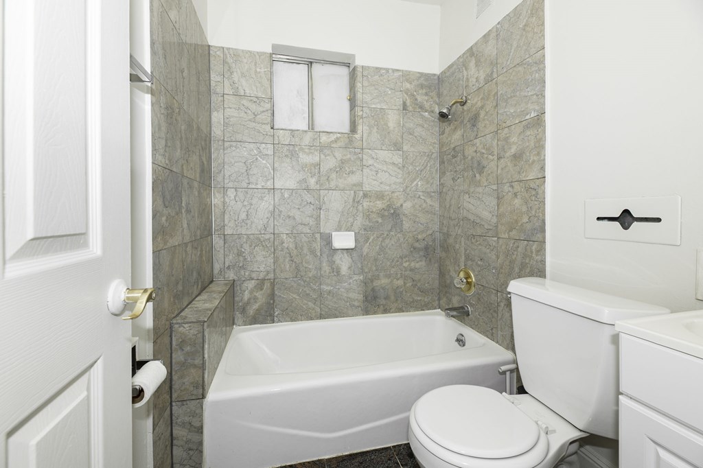a white bathroom with a tub and a toilet