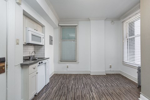 A kitchen with white cabinets and a microwave above the stove.