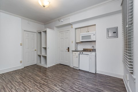 A kitchen with white cabinets and a microwave above the stove.