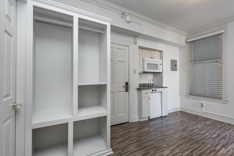 A kitchen with white cabinets and a microwave.
