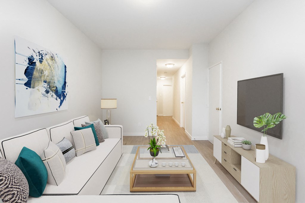 A modern living room with a white sofa, a coffee table, and a painting on the wall.