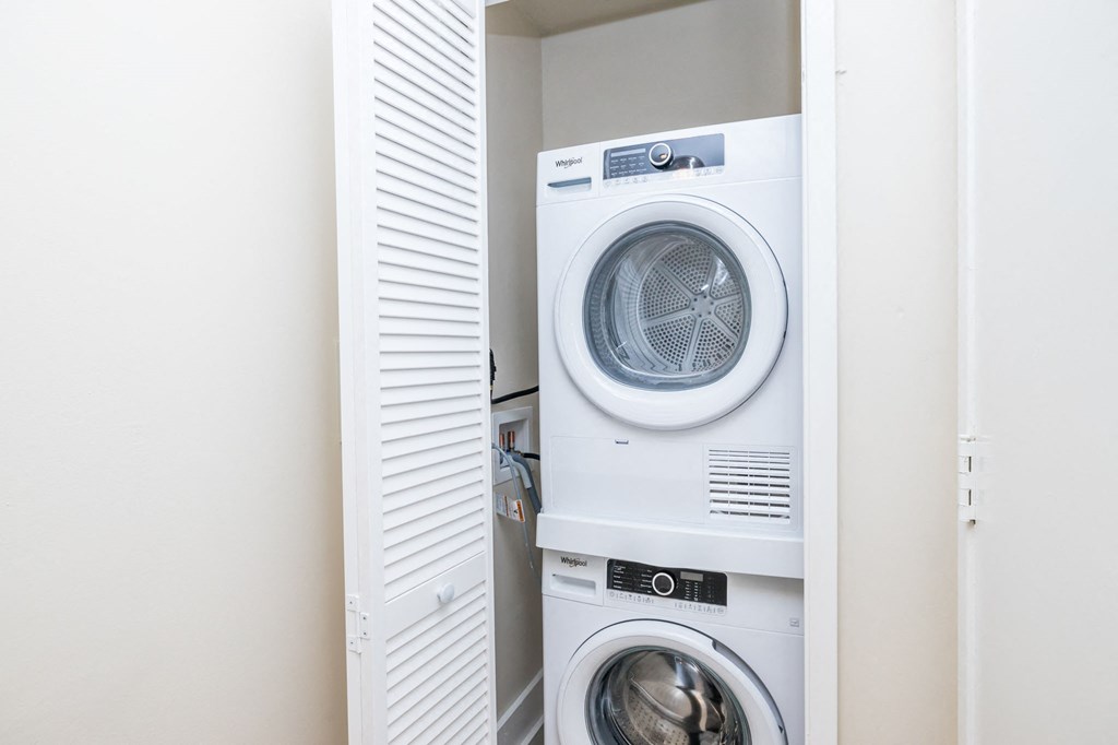 A white washing machine is in a cabinet.