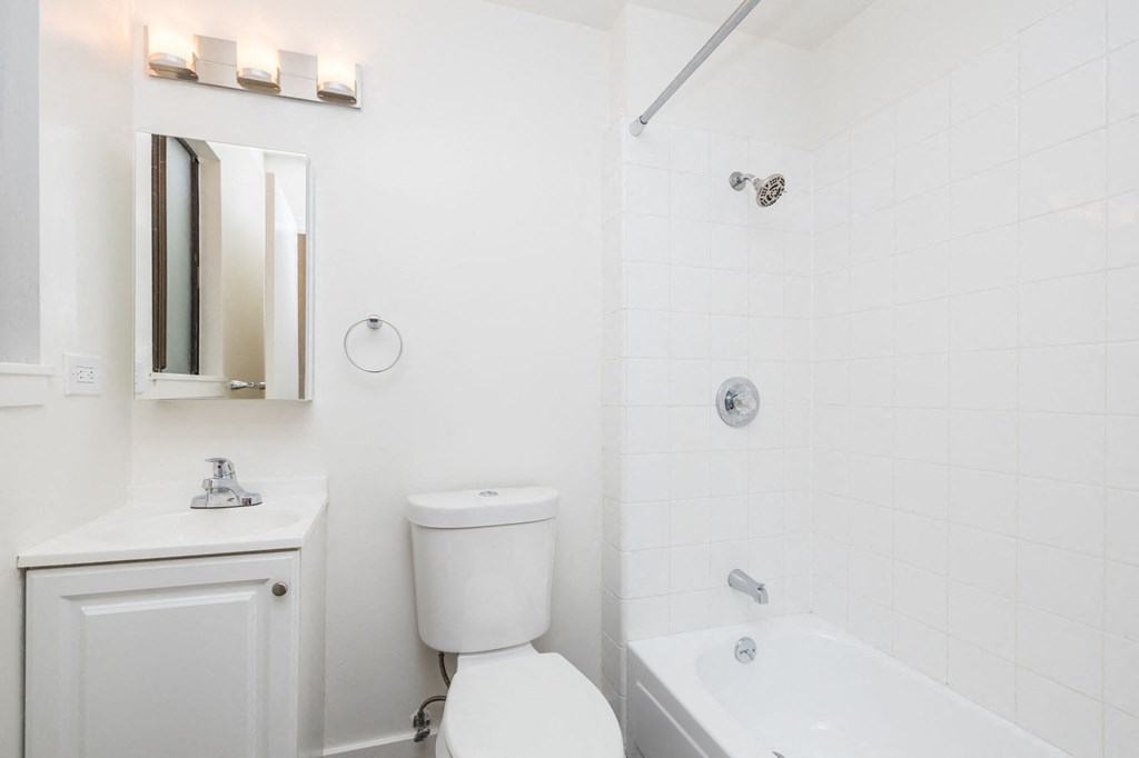 A white bathroom with a toilet, sink, and bathtub.
