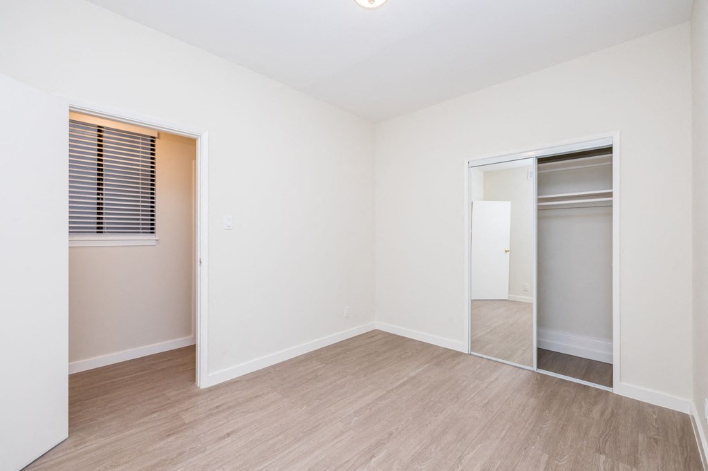 A room with a white door and a window with blinds.