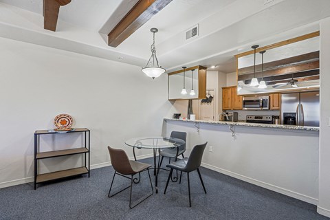 A dining room with a glass table and chairs.