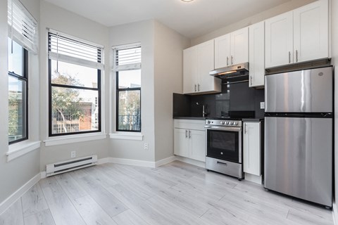 a renovated kitchen with white cabinets and stainless steel appliances