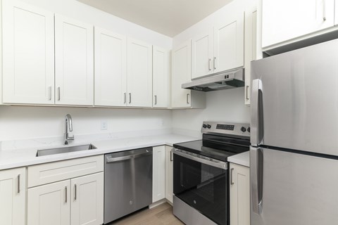 A kitchen with white cabinets and stainless steel appliances.
