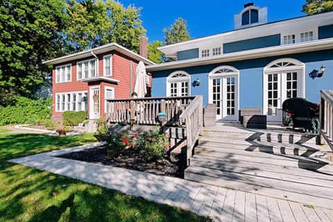A red house with a white fence and a wooden deck.