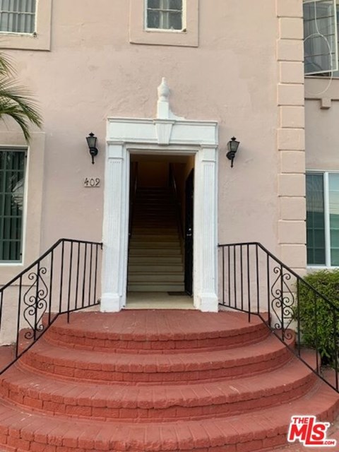 A house numbered 402 has a red staircase leading to a white door.