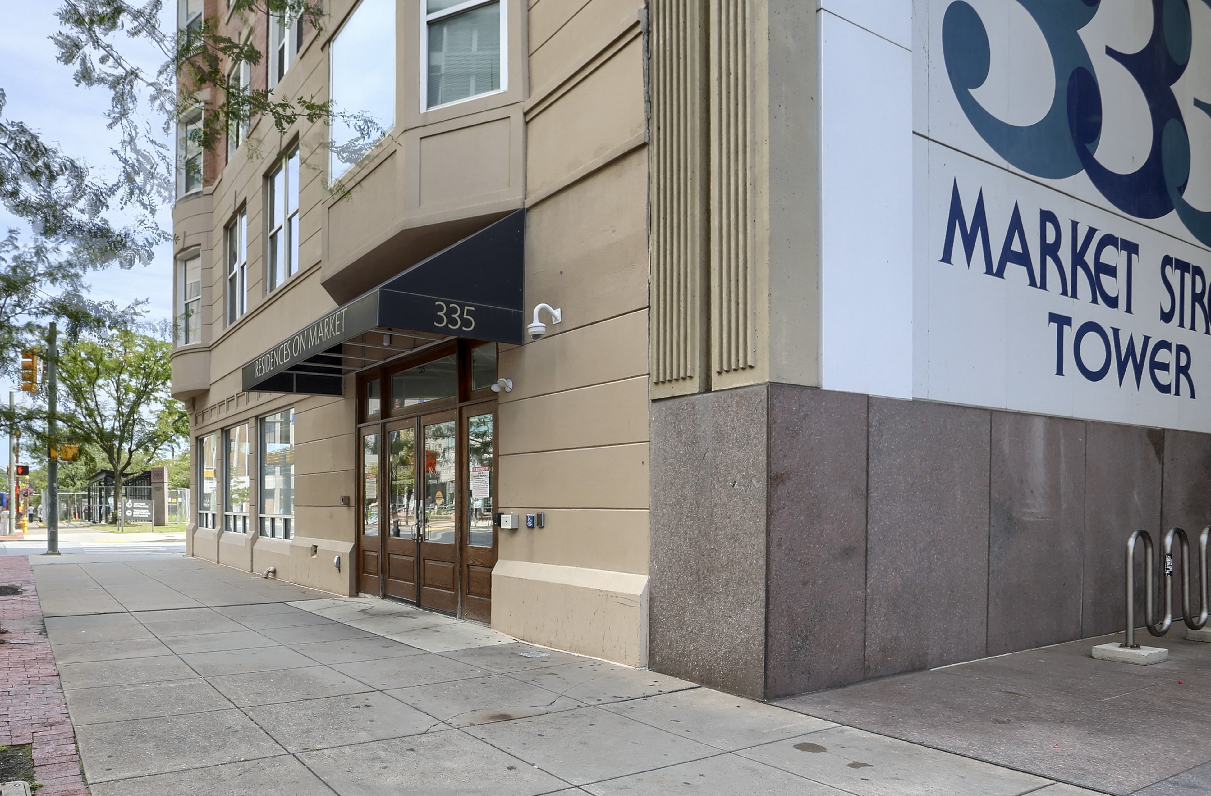a market street tower building with a sidewalk in front of it