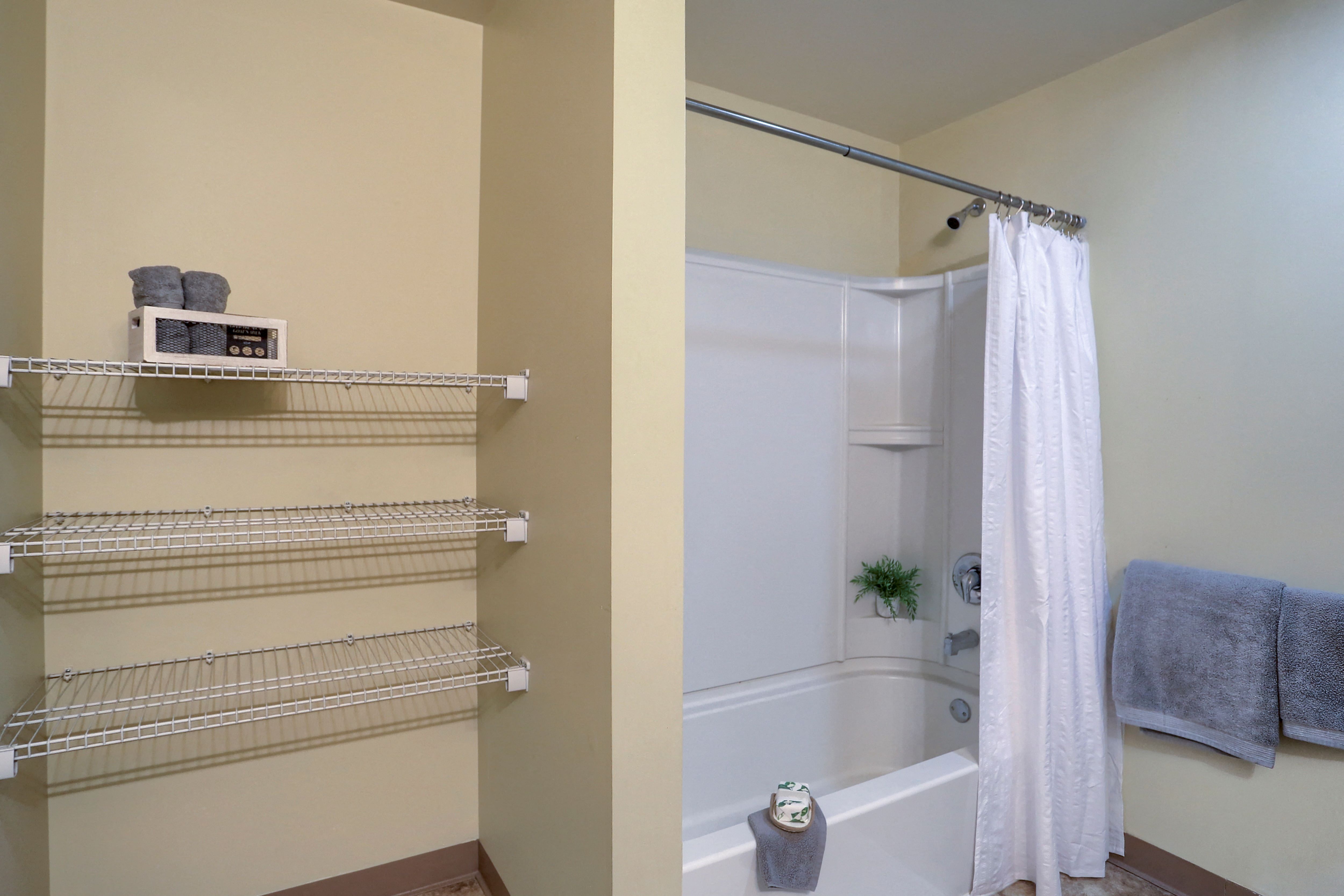 a bathroom with a shower and a tub and a towel rack and a shower curtain