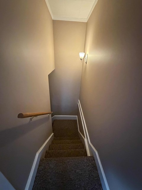 A stairway with a light on the wall.